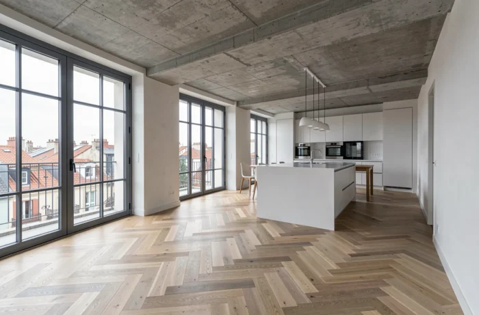Appartement rénové à vendre à Bordeaux avec parquet en chêne, plafond béton et fenêtres industrielles donnant sur les toits