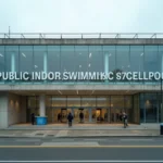 Façade extérieure de la piscine Jules Verne à Nantes avec des nageurs se dirigeant vers l'entrée